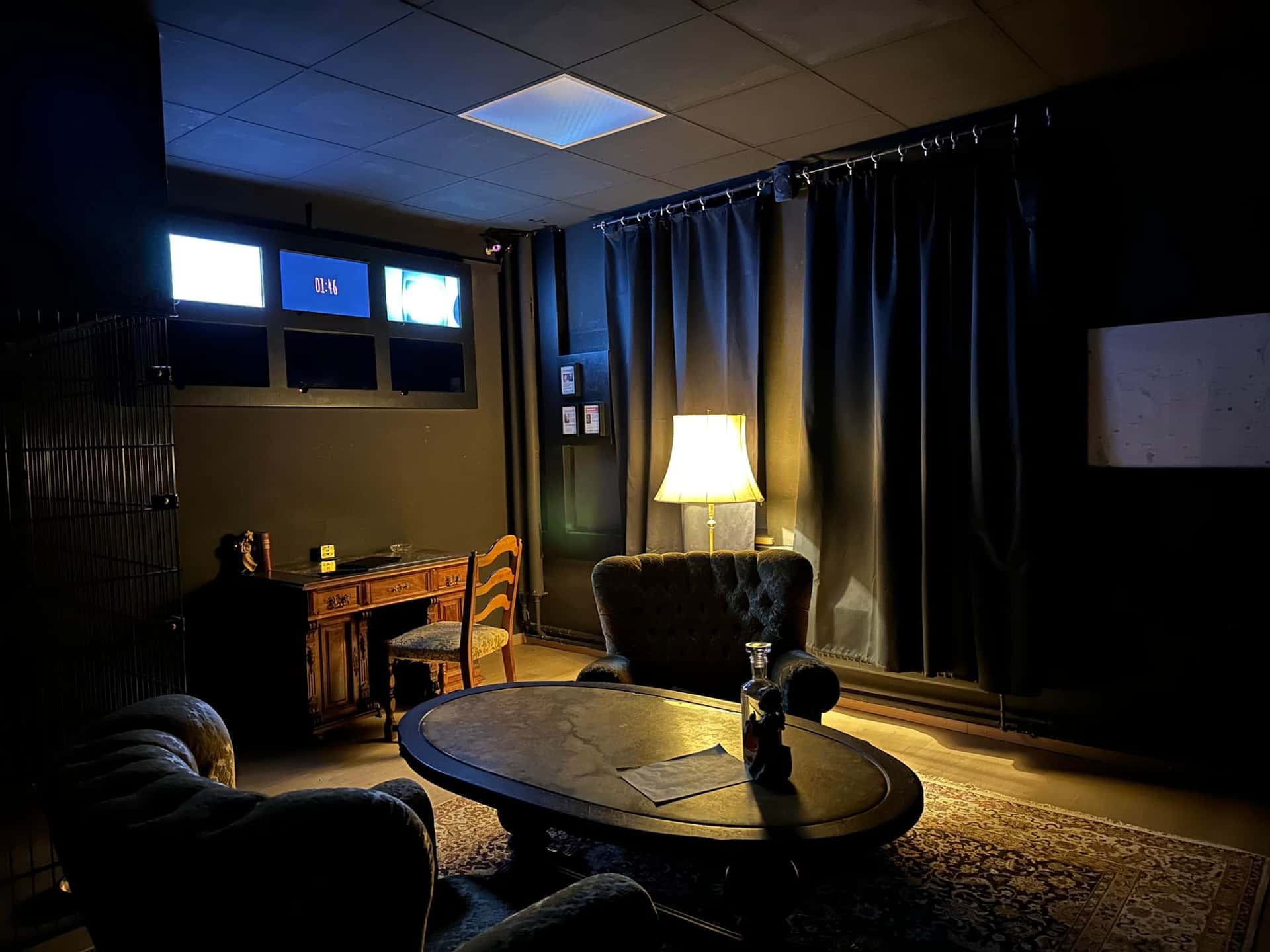 Dunkles Wohnzimmer mit Ohrensesseln, Couchtisch und Stehlampe im Escape Room Blutrausch in Rosenheim