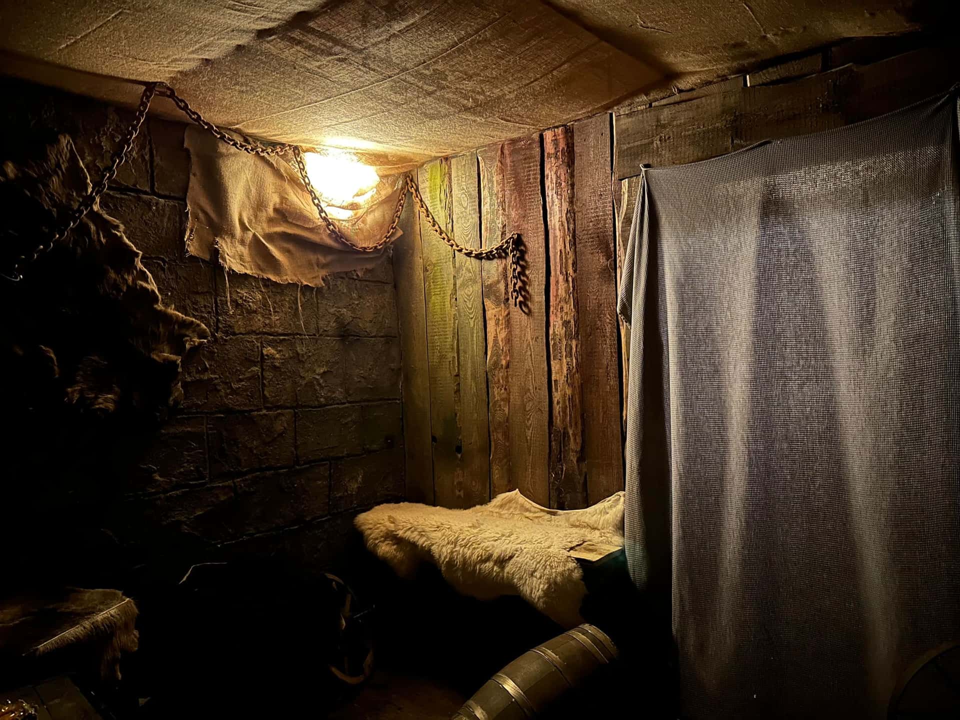 Kerkerzelle mit Strohlager, Ketten und Laterne im Escape Room Der Henker in Rosenheim