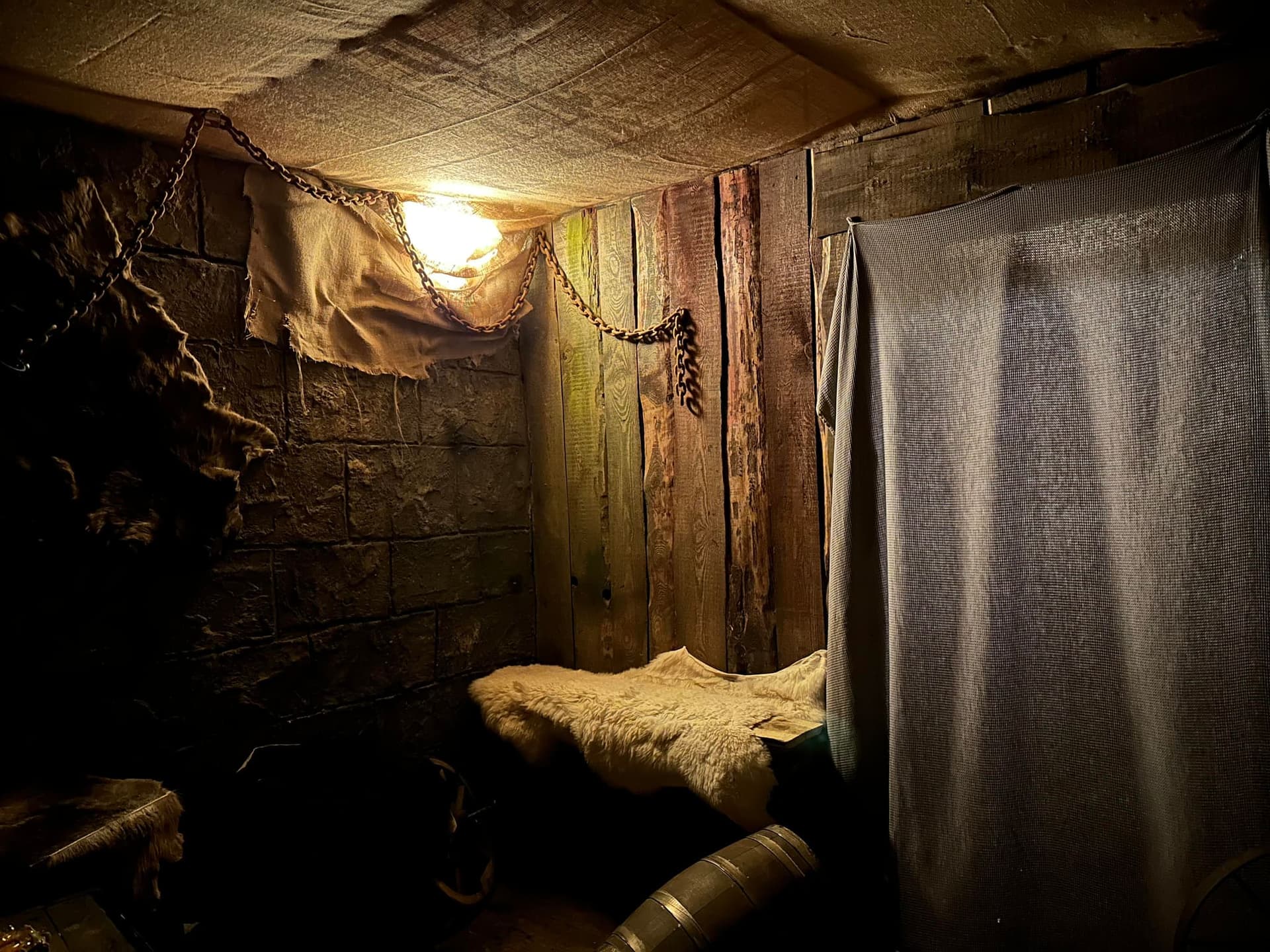 Kerkerzelle mit Strohlager, Ketten und Laterne im Escape Room Der Henker in Rosenheim