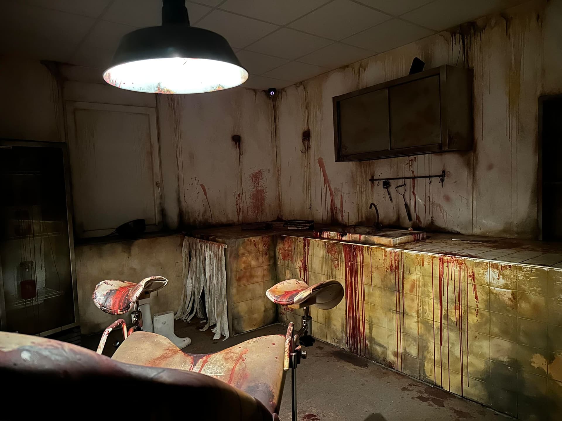 Schlachtraum mit Hängelampe, blutiger Theke und Behandlungsstuhl im Escape Room Blutrausch in Rosenheim